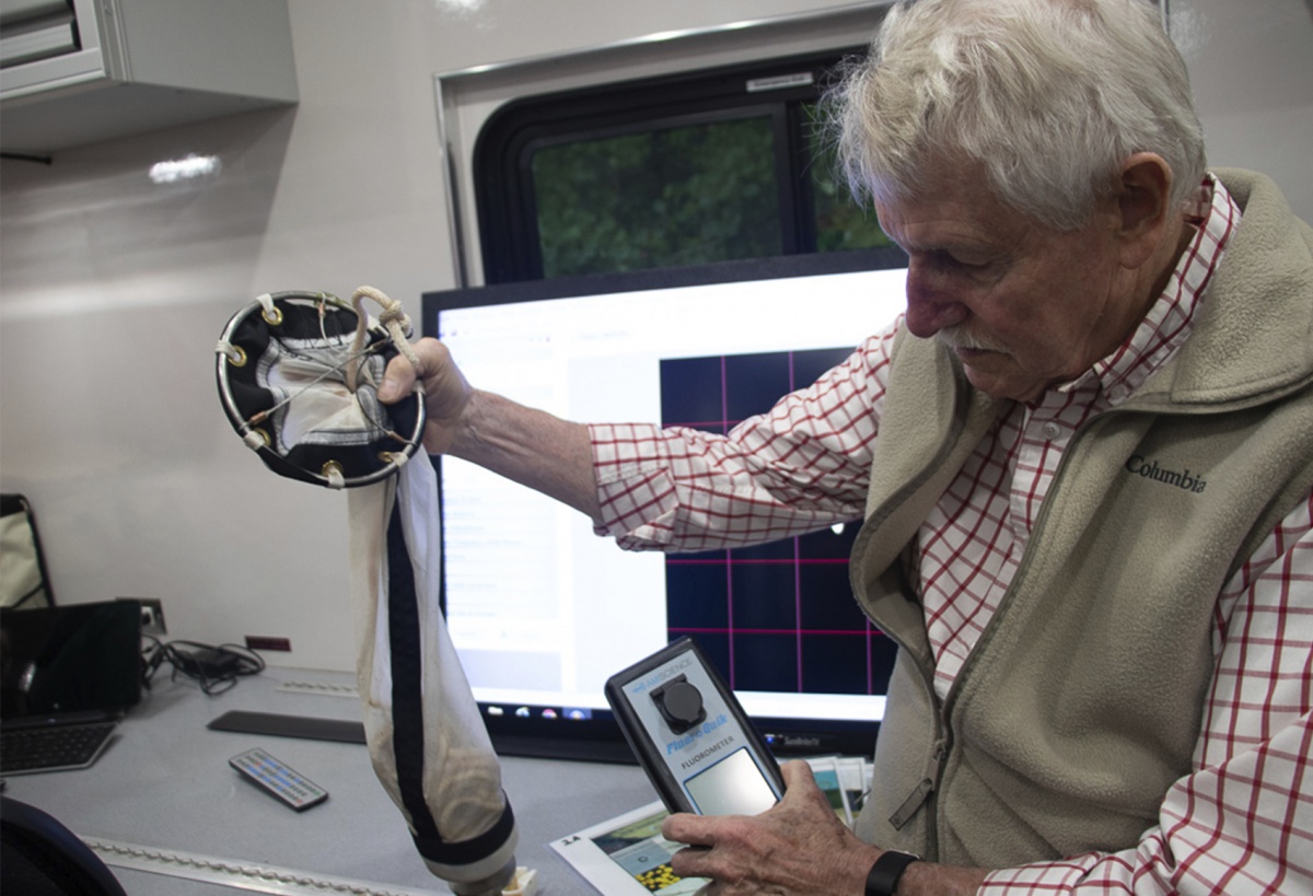 James Haney, Ph.D., holds up equipment used to monitor cyanobacteria.