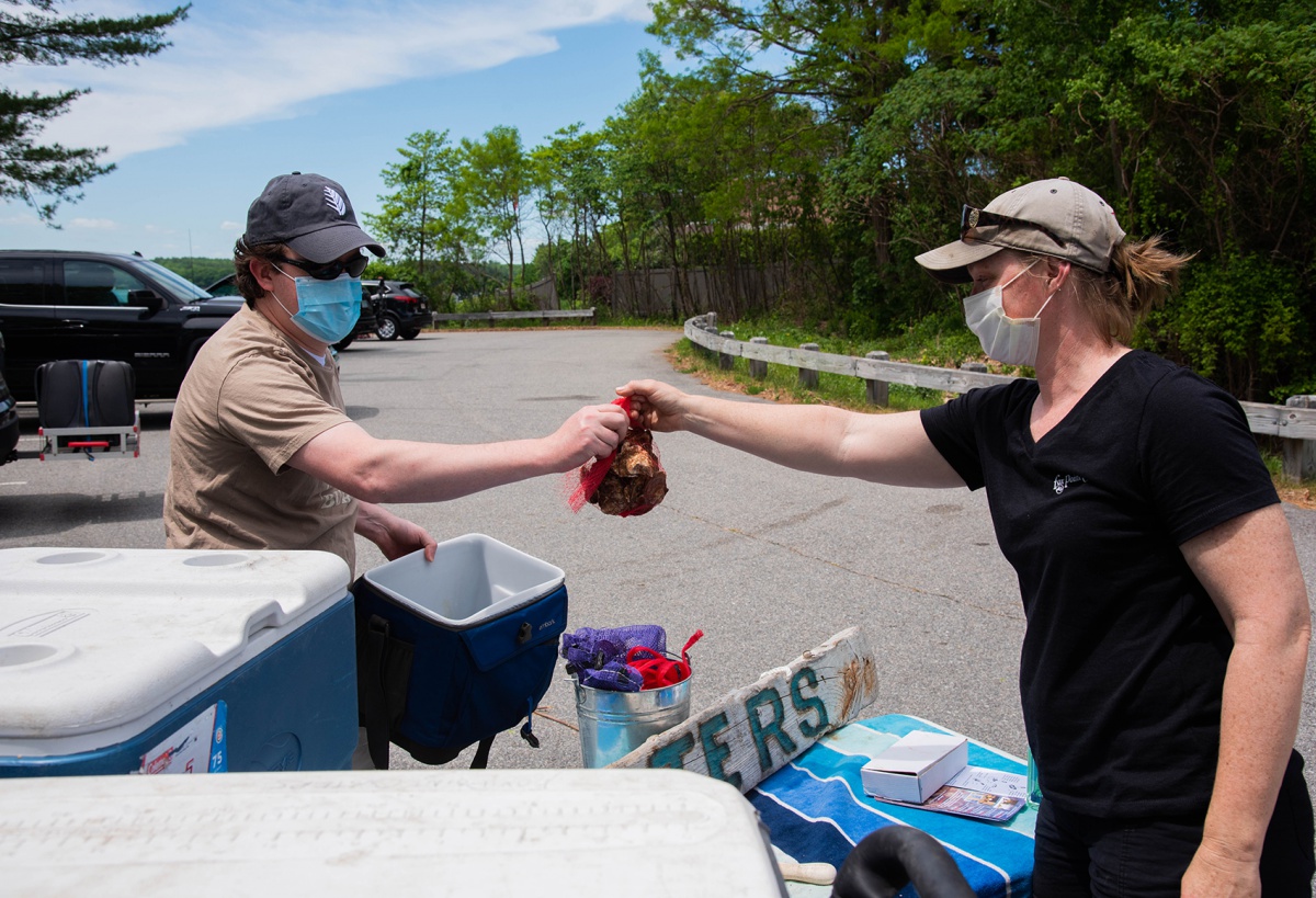Lauren Brown handing off oysters to a customer at her stand