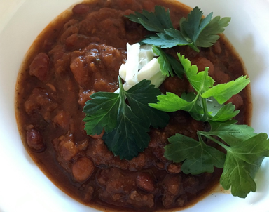 Bowl of Pinto Bean Chili with cheese and fresh cilantro