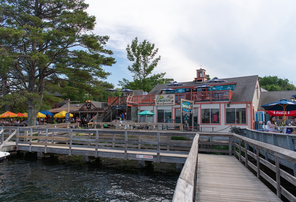 Boardwalk near trail and water with restaurant and diners