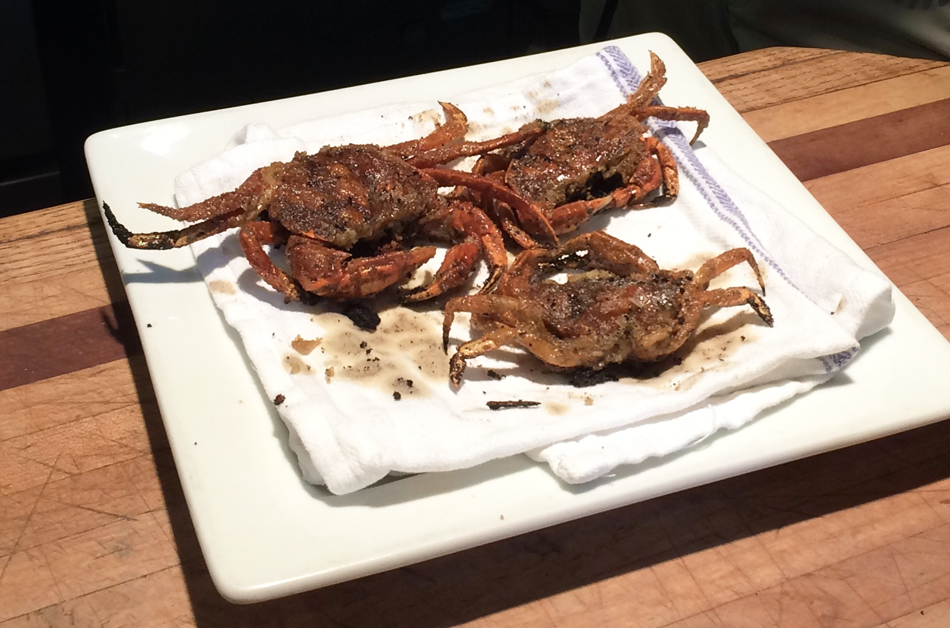 Green crabs prepared as an appetizer on a plate.
