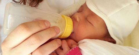 Baby getting fed with bottle