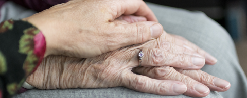 Two older people's hands on top of each other