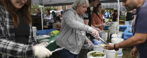 serving pickles to a line of festival goers