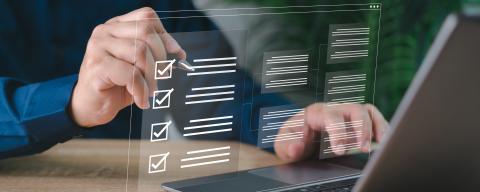 Person checks off a list floating in the air in front of a laptop - NongAsimo - stock.adobe.com
