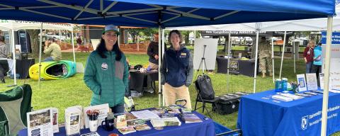 Two UNH Extension staff members at a table and tent set up 