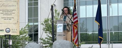 A woman at a podium on a outdoor stage