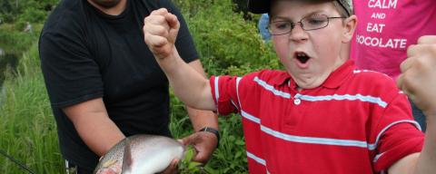 Photo of a proud angler with a huge rainbow trout at BCC.