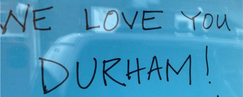 Blue sign reading "We love you Durham"