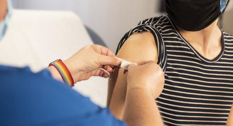 Man getting BAND-AID placed on arm after shot