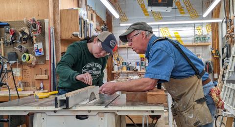Instructor and intern at a table saw in a woodworking shop