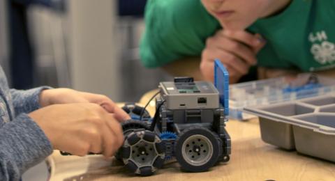 two students from 4-H working on a robot 