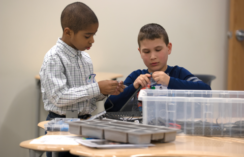 Two children making a STEM contraption