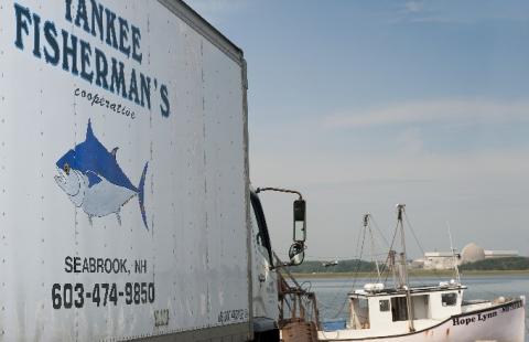 yankee fisherman's box truck with fishing boat in distance