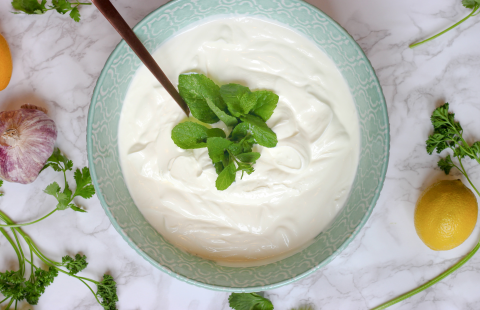 Bowl of yogurt with herbs a lemon and garlic.