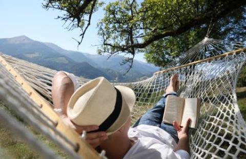 Man reading a book in a hammock
