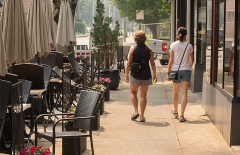 Two people walking down city street