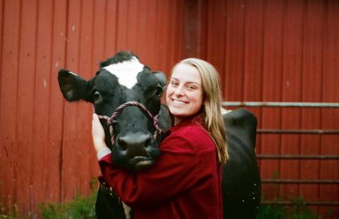 Andrea Majewski with cow in front of red barn