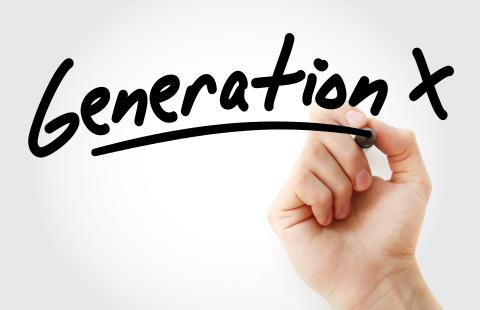 Hand of peson writing out Generation X with a black marker.