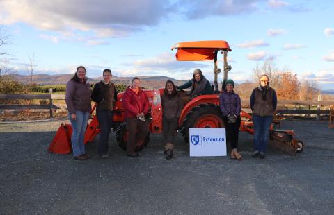 Women standing in front of tractor with UNH Extension sign