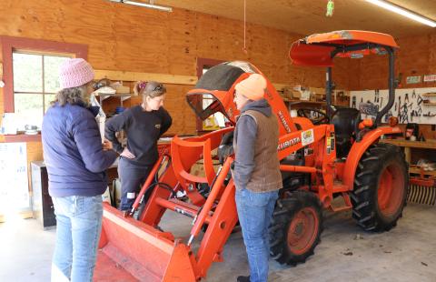 Women standing around a tractor