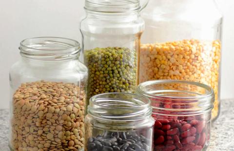 5 open canning jars containing dried beans, lentils, and corn kernels