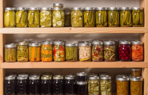 rows of home canned vegetable and preserves in glass canning jars