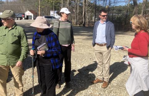a group of people standing in a gravel parking lot 