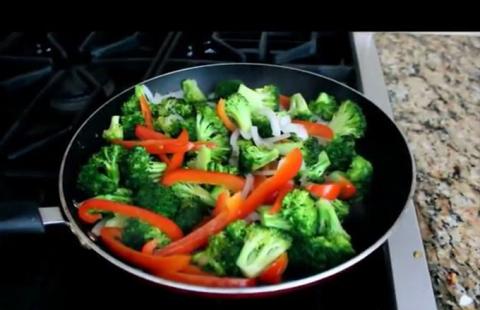 Skillet with broccoli, red pepper strips and chopped onion.