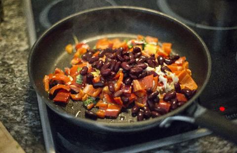 Skillet on stove top with chopped peppers, onion and kidney beans.
