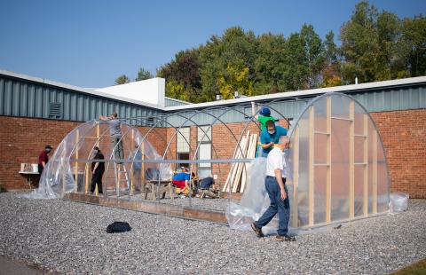 Volunteers assisting with construction of a hoop house 