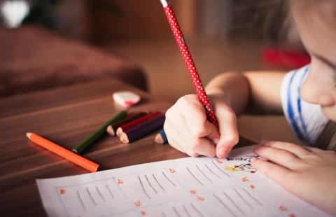 child coloring with pencil