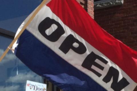 open flag outside store 