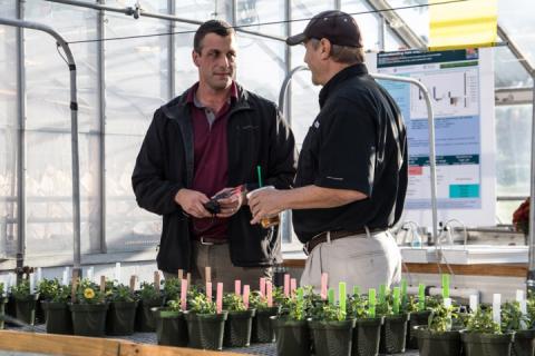 two men standing in a greenhouse