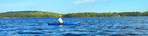 man kayaking on a NH lake