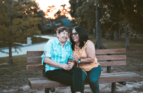 Two people sitting on a bench laughing