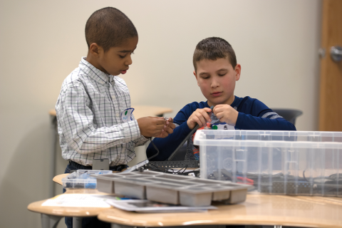 Two children making a STEM contraption