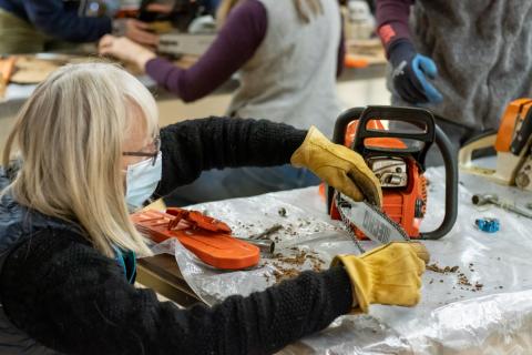 participant cleaning a chainsaw