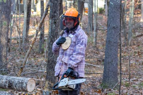 participant smiling and holding a tree cookie