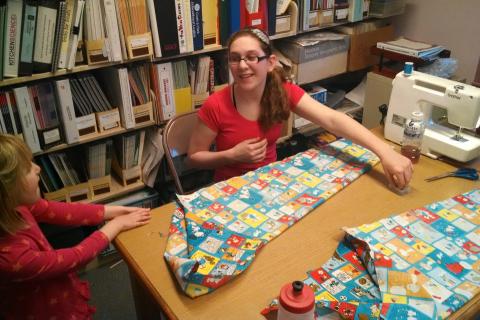 Kids enjoy a sewing activity.