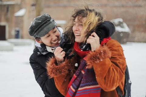 Two females joyously embracing in winter