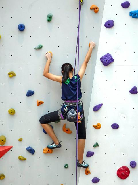 Youth climbing an indoor climbing wall