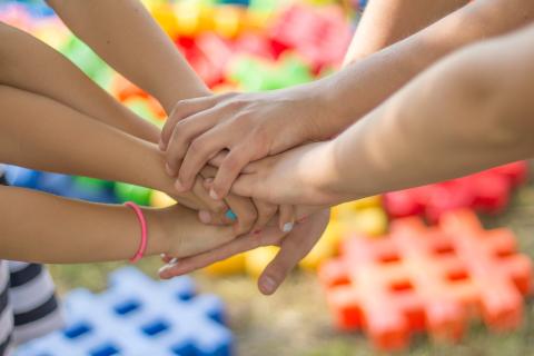 Hands coming together for team spirit expression.