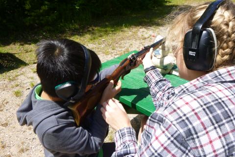 A summer camper getting trained in firearm safety.