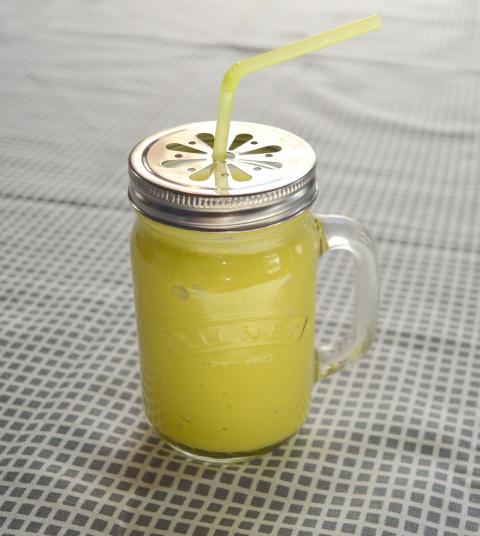 Smoothie in covered glass with straw