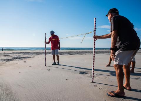 Men measuring on beach