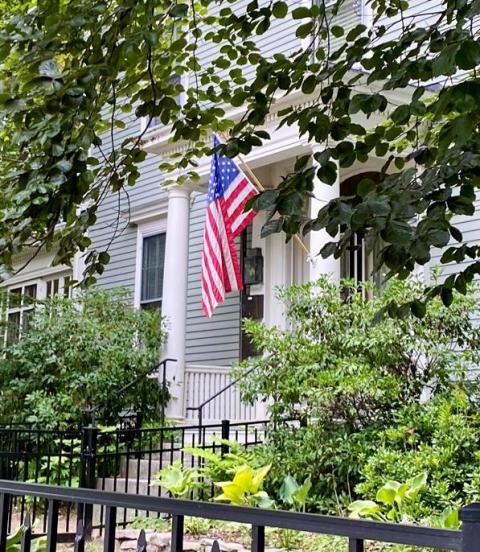 front door of a grey house with an American flag