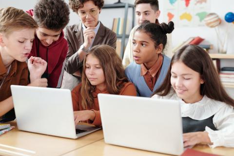 Students in a classroom looking at laptops.