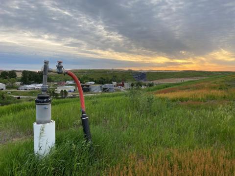 grassy landfill with methane gas monitoring wellhead