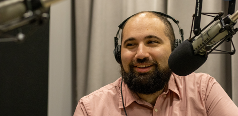 Nate Bernitz wearing headphones and speaking into a microphone